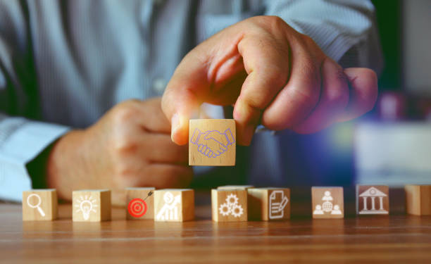 istock business man holding square wood cube with futuristic element digitalicon hand shaking 1454621018