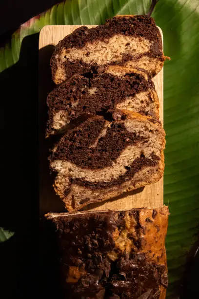 Slices of Banana Bread infused with chocolate on a background of banana leaves