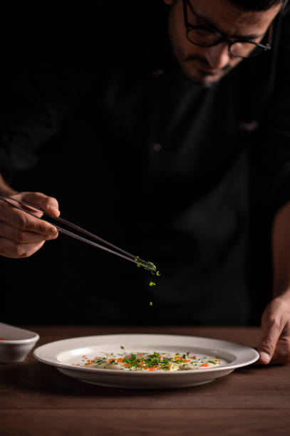 istock Chef putting some seasonings on lasagna 1454623576