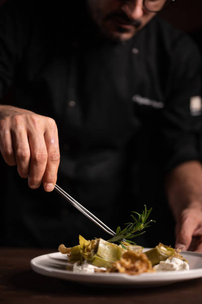 istock A male chef decorating a plate of artichoke 1454623665
