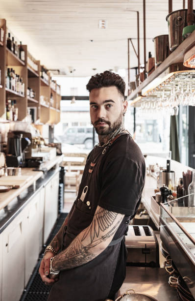 istock Young tattooed barman working at the bar 1454623698