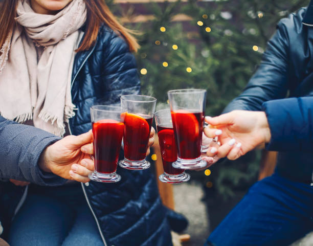 Friends drinking delicious mulled wine at party Friends drinking delicious mulled wine at party. Shot of a group of cheerful young friends having fun and enjoying hot drink on the Christmas market at an evening party. Close up mulled wine stock pictures, royalty-free photos & images