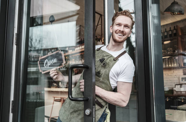 istock Young redhead barman opening the bar 1454624335