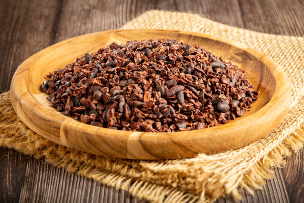 nibs de cacao en plato de madera. - cocoa cocoa bean chocolate brazil fotografías e imágenes de stock