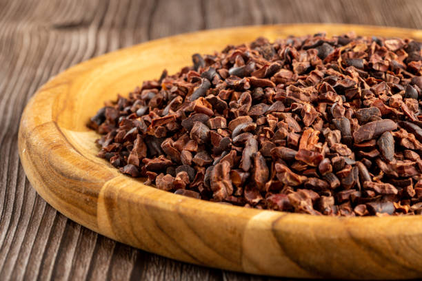 nibs de cacao en plato de madera. - cocoa cocoa bean chocolate brazil fotografías e imágenes de stock