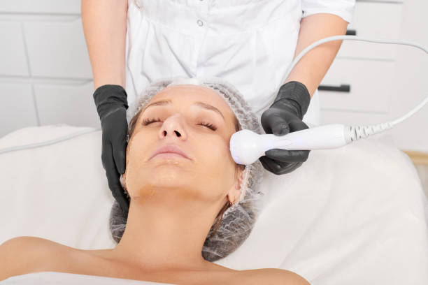 kosmetolog wykonuje lifting rf dla odmłodzenia twarzy kobiety, zabieg kosmetyczny przeciwstarzeniowy - częstotliwość zdjęcia i obrazy z banku zdjęć