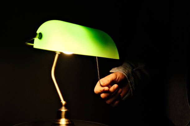 istock Turning off a green lamp black background 1454626273