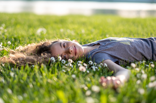 the girl is lying down on the grass
