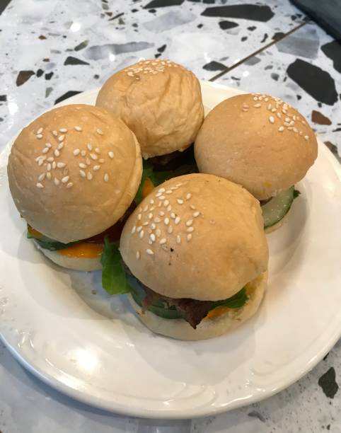 istock 4 mini burgers served on a white plate 1454631644