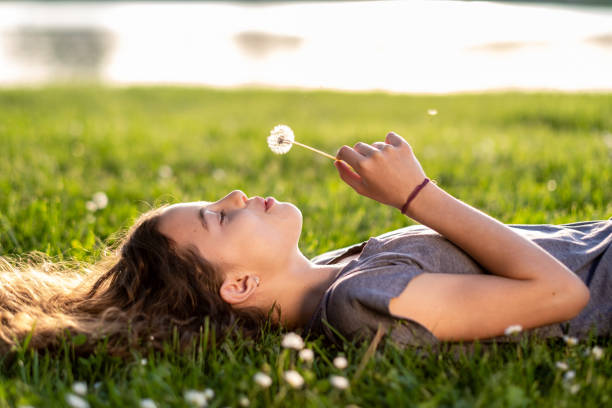 istock a little girl blows a flower 1454631913