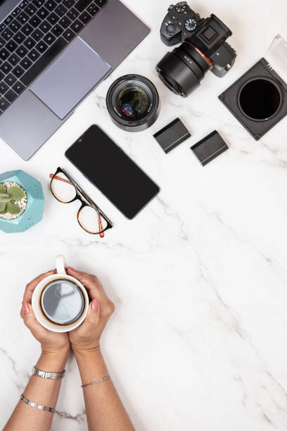 istock Photographer white marble desk with copy space on right holding coffee with hands 1454632495