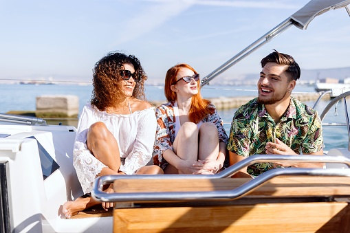 Luxury life style concept with young multi ethnic people on sailboat excursion.