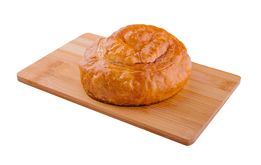Fresh twisted bun on wooden board