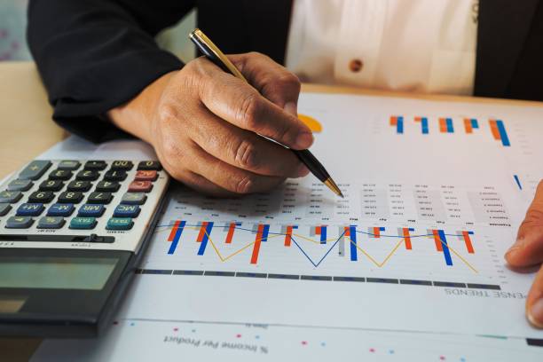 istock Asian accountant working and analyzing financial reports project accounting with chart graph and calculator in modern office, finance and business concept. 1454638716