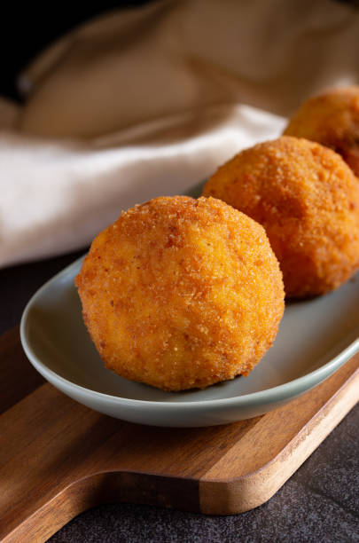 istock Fried stuffed Sicilian arancini with breadcrumbs crust 1454639346