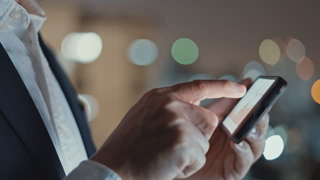 Businessman using smartphone in an office at night,Close-up