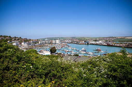 Boats in Torquay Harbour in Devon, with town and shops behind