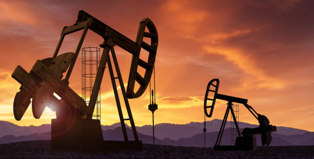Oil pumps at sunset Oil pumps extracting crude at sunset. Oil drill and pump jack in oilfield. oil industry stock pictures, royalty-free photos & images