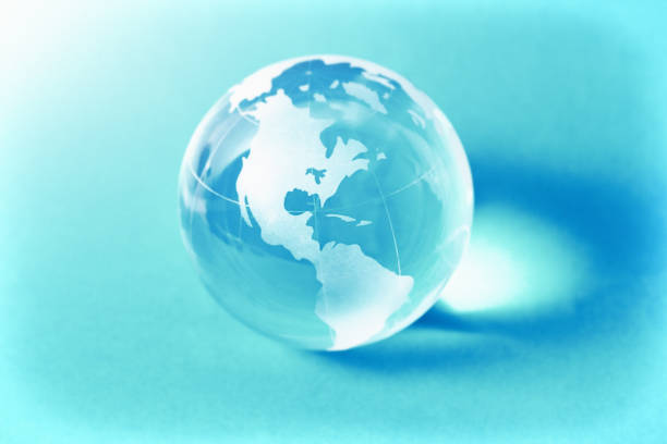 istock Crystal glass world globe on turquoise, the Americas facing the camera, with copy space 1454645596