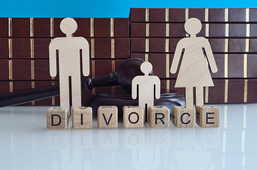 Separation of wooden figure of divorce family with gavel on wooden table in courtroom. Cheating quarrel divorce and elements on children