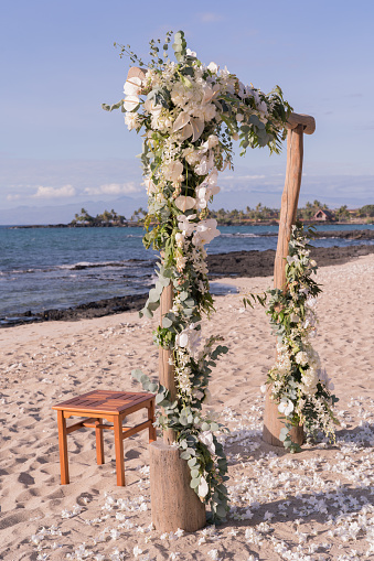 White flowers, arch, glasses. Beautiful wedding decor, blue sky sand sea