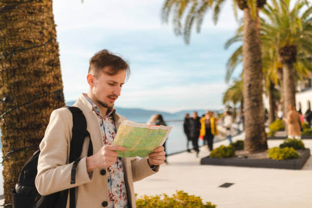 istock Handsome young male tourist looking at the map while on a vacation holiday 1454660023