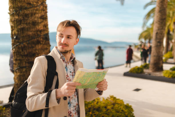 istock Lost young tourist looking at the map while on a summer vacation 1454660037