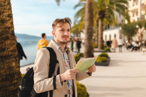 istock Lost young tourist looking at the map while on a summer vacation 1454660049
