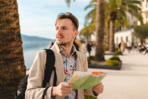 istock Lost young tourist looking at the map while on a summer vacation 1454660050