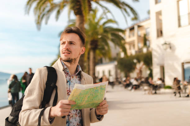 istock Lost young tourist looking at the map while on a summer vacation 1454660055