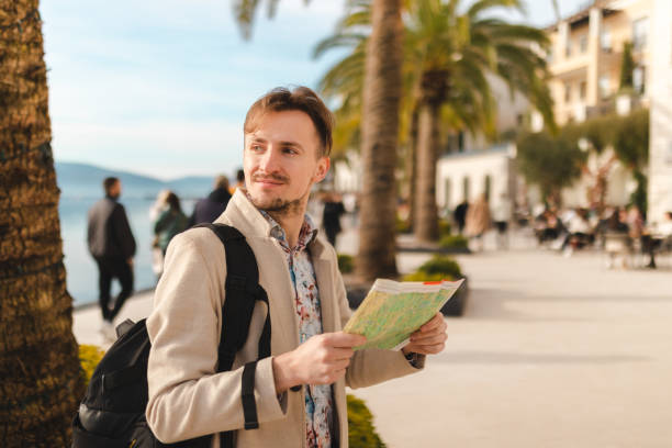 istock Lost young tourist looking at the map while on a summer vacation 1454660056