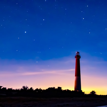 A few bright stars appear in the sky around the Barnegat Lighthouse at dusk