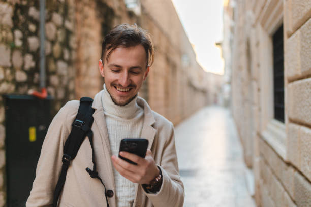 istock Young male tourist using his phone while visiting old town Dubrovnik 1454661399