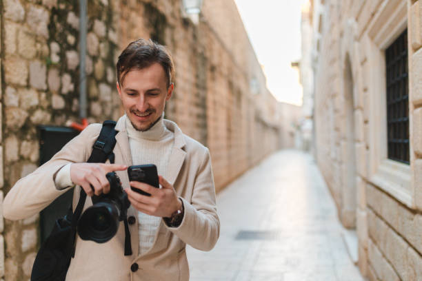 istock Young male tourist using his phone while visiting old town Dubrovnik 1454661419