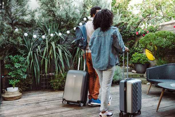 istock Happy travelling young couple with suitcases leave the accommodation 1454662714