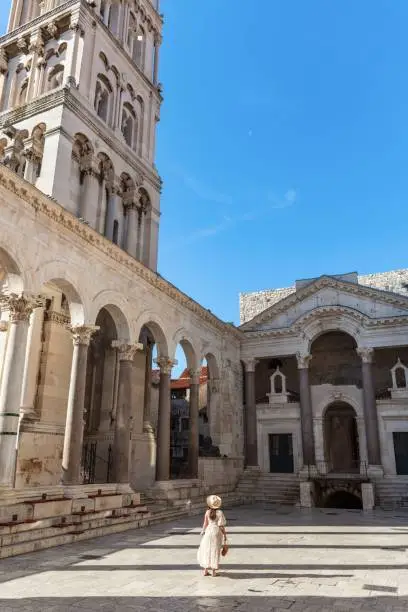 A Caucasian female standing on the peristyle of the Diocletian's Palace in Split, Croatia