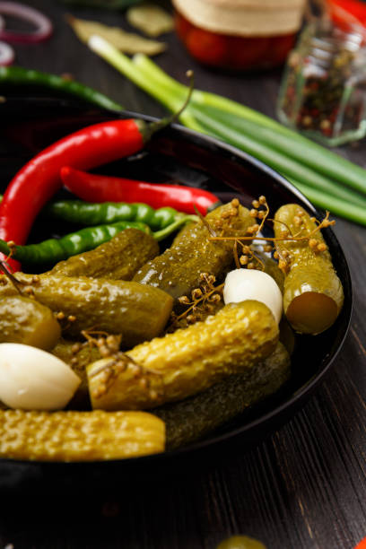 istock Assorted pickled vegetables in a black plate on a dark background. 1454665920