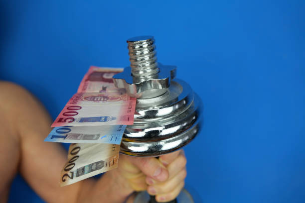 istock Hungarian forint banknotes and a dumbbell held in hand 1454669048