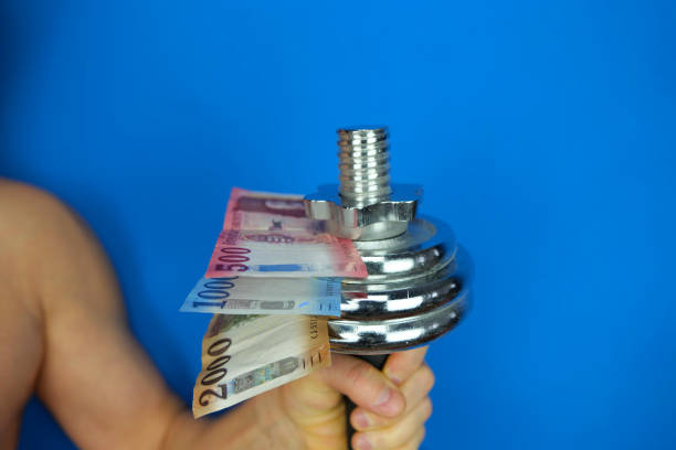 istock Hungarian forint banknotes and a dumbbell held in hand 1454670737