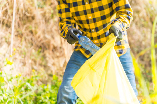 istock Unrecognizable man's hand collecting plastics in a forest. Ecology concept, recycling 1454671540