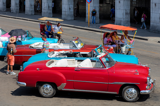 Havana, Сuba - April 21, 2018: Vintage American cars waiting for passengers in Havana Vieja, Cuba.