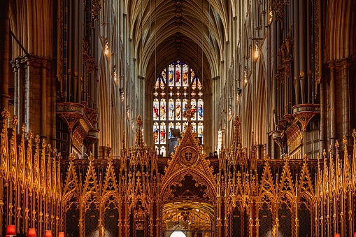 An inside view of Westminster Abbey with an arched roof and altar
