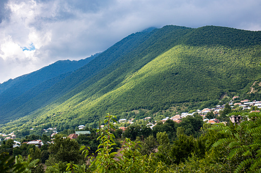 photo of a small village among green mountains on a sunny summer day