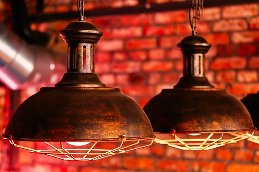 A steampunk style design element lamps hanging view over red brick wall close up