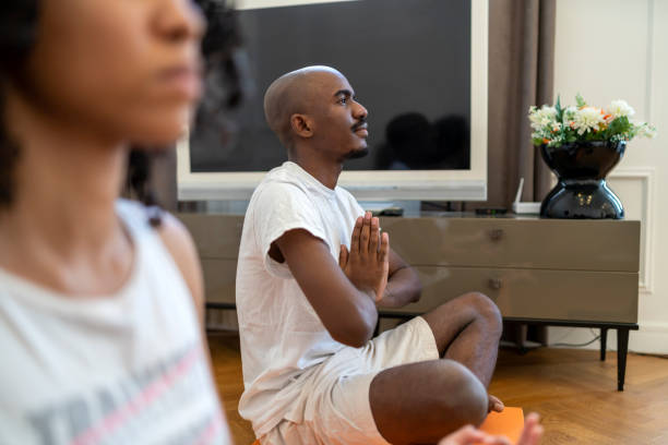 istock African-American guy and his girlfriend practicing yoga 1454686928