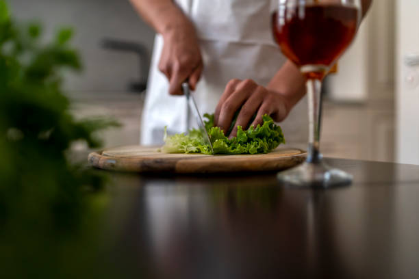 Detail shot of cutting vegetables and a glass of wine in the kitchen