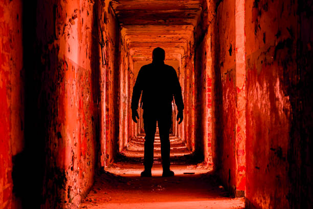 A man silhouette in an abandoned building walkway, red toned version.