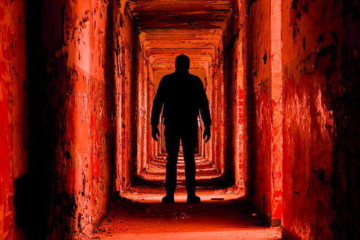 A man silhouette in an abandoned building walkway, red toned version.