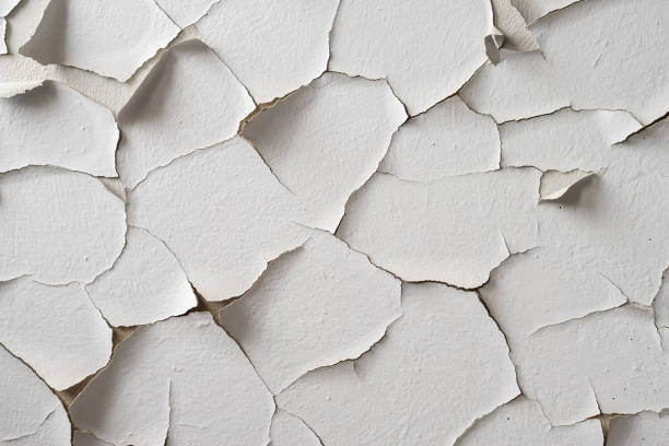 ひび割れや剥がれたペンキの破片で白く塗られた壁。フレーク状の塗料 - peeling paint wall white ストックフォトと画像