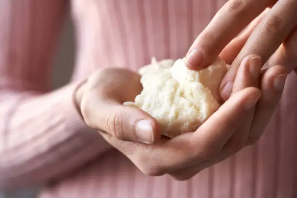 Woman holding raw unrefined shea butter or karite in her hands